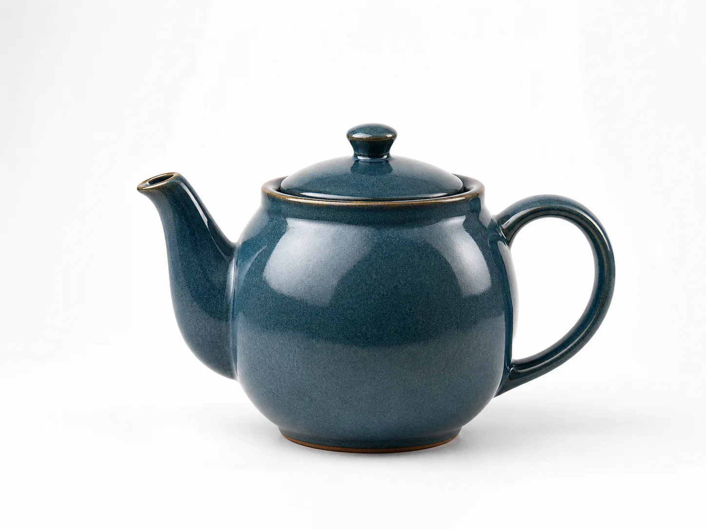 Product hero shot of a glazed ceramic teapot, controlled three-point studio ligh